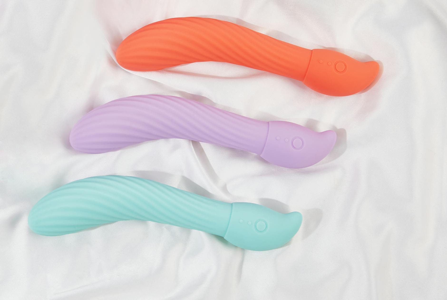 Woman holding colorful clitoral vibrators and considering sensation options