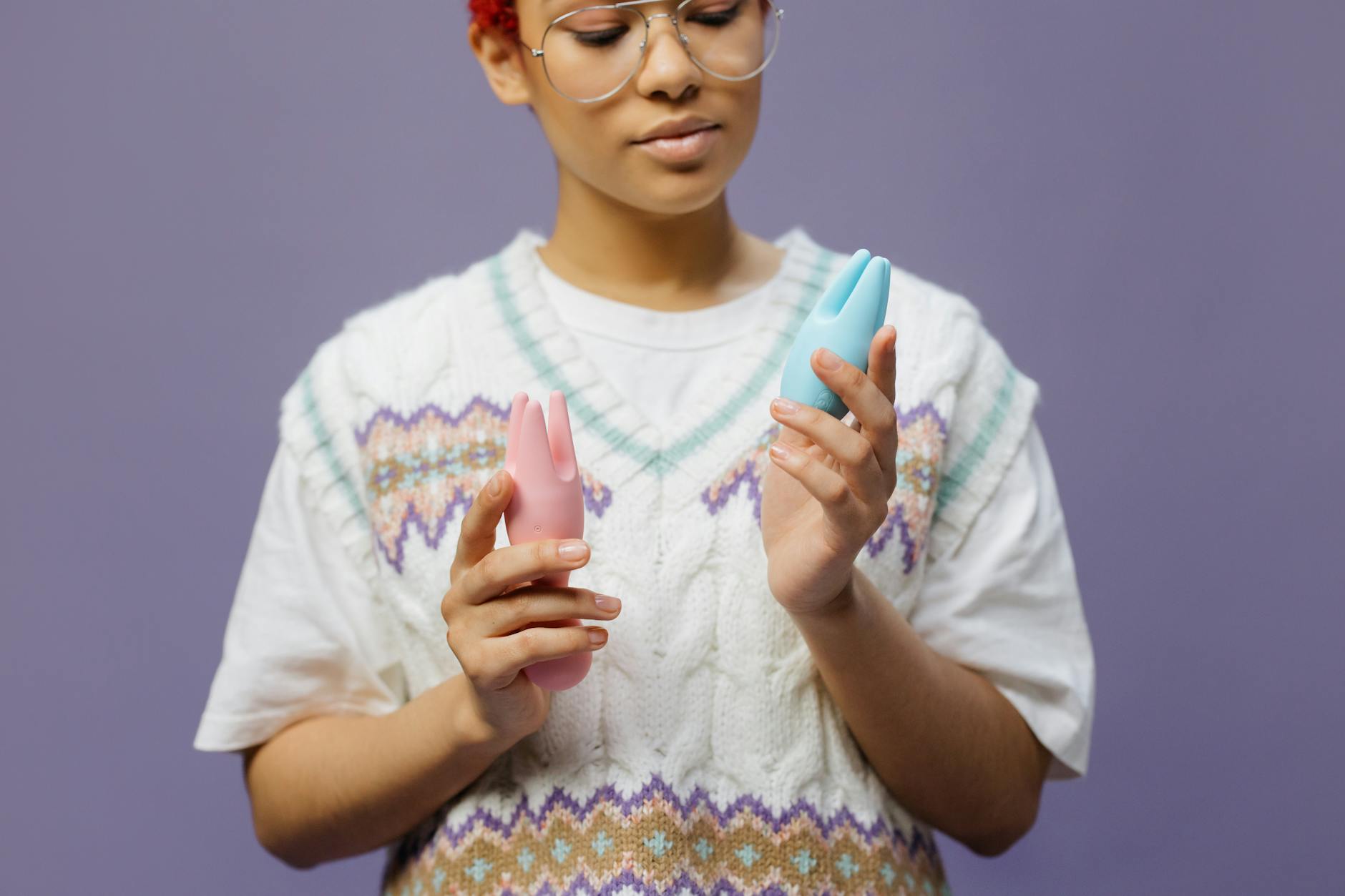 Woman holding blue and pink lemon vibrators thoughtfully, representing the journey of rebuilding pleasure after depression.